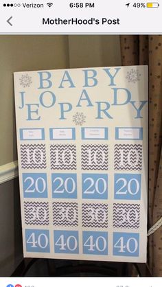 a baby shower sign hanging on the wall next to a window with curtains and drapes