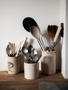 kitchen utensils and spoons are sitting in small containers