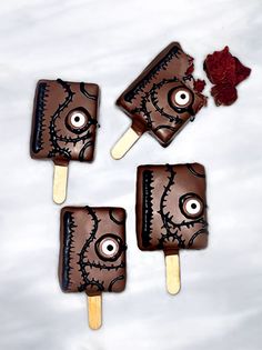 three chocolate covered pops with eyes on them