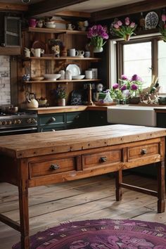 a wooden table sitting in the middle of a kitchen next to a stove top oven