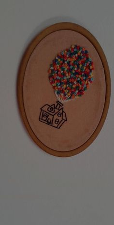 a wooden frame with a drawing of a house and tree on it