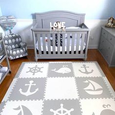 a baby's room with a gray and white rug