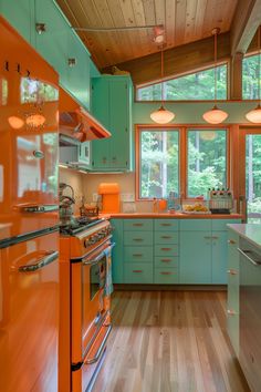 an orange and blue kitchen with wood flooring