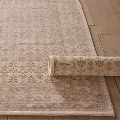 the rug is laying on the wooden floor with it's edge pulled back to reveal an interesting pattern