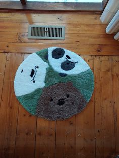 a round rug with bears on it in the middle of a wooden floor next to a radiator