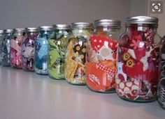 a row of colorful glass jars sitting on top of a counter