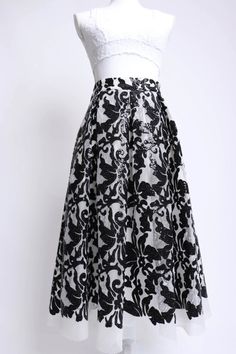 Description: Eliza J 00's black and white sequin mesh floral patterned midi skirt This skirt was designed with comfort in mind Features a soft lined waist with a hidden zipper and black elastic inserts on either side The white polyester mesh is soft and squishy and decorated with little black sequins in a pretty floral pattern The pleated waist gives way to a full skirt, and it has silky lined pockets Fully lined in white polyester fabric Model is 5'11" Waist 29" Hips 40" Length 30" Details: Siz Black Sequined Skirt For Spring, Glamorous Black Spring Skirt, Spring Black Sequin Skirt, Formal Black Sequin Skirt, Long Black Sequined Skirt, Elegant Black Skirt With Contrast Sequin, Black Long Sequin Skirt, Patterned Midi Skirt, Mesh Midi Skirt