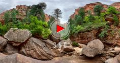 a red arrow is in the middle of some rocks and trees on a cloudy day