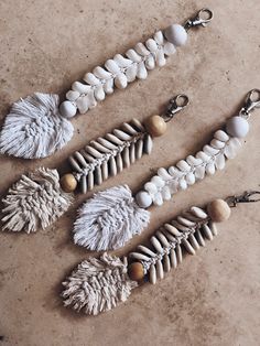 three different types of beaded and feathered keychains on a table top