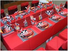 a table set up with cars themed plates and napkins