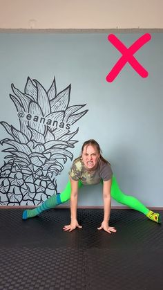 a woman in green leggings and a gray shirt is on the floor with her hands behind her head