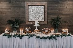 a table topped with lots of food next to a wall covered in wooden planks