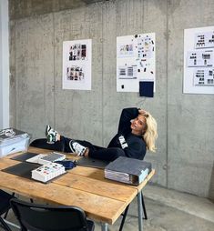 a woman sitting at a table with her feet up