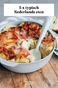 a casserole dish with bacon and potatoes in it on a wooden table next to an apple