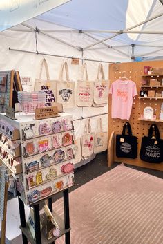 there are many bags on display in the store and one has a t - shirt