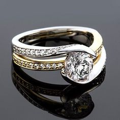 two tone gold and silver wedding ring set with diamond accenting the band, on a reflective surface