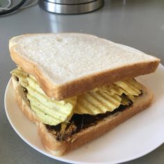 an egg and bacon sandwich on a white plate