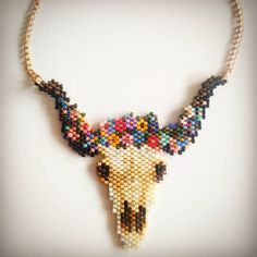 a beaded cow skull is displayed on a necklace