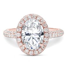 a rose gold ring with an oval cut diamond surrounded by pave and round brilliant diamonds