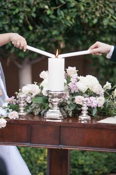 the bride and groom are lighting candles on their wedding day