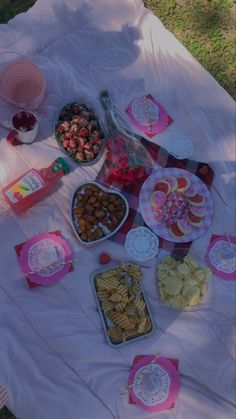 a table topped with lots of food on top of a blanket