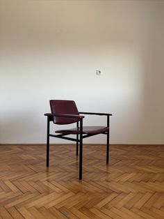 a chair sitting on top of a hard wood floor next to a white wall and wooden floors