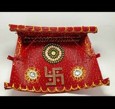 a red and gold decorated tray with decorations on it