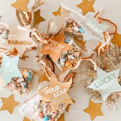 several bags filled with treats on top of a white table cloth covered in confetti