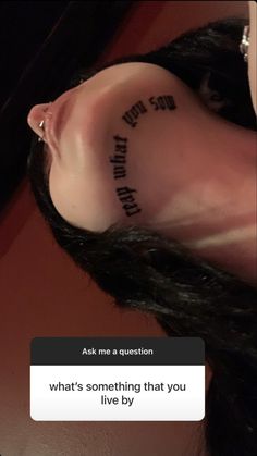 a woman with a tattoo on her ear saying what's something that you live by