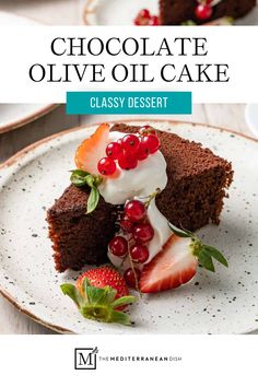 chocolate olive oil cake on a white plate with strawberries and whipped cream in the middle