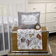 a stuffed animal sitting on top of a bed next to a baby crib in a room