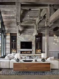 a large living room with wooden ceilings and white couches