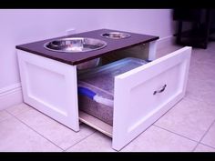 a dog bowl is in the bottom drawer of a cabinet that has its door open