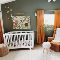 a baby's room with green walls and white furniture