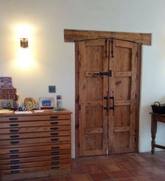 a room with two wooden doors and a dresser