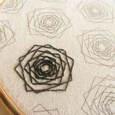 a close up of a cross stitch pattern on a piece of cloth with black thread