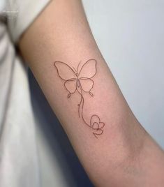 a woman's arm with a butterfly tattoo on the left side of her arm