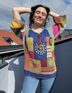 a woman standing on top of a roof with her hands behind her head and smiling