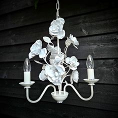 a white chandelier hanging from a wooden wall