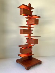 a tall wooden sculpture with lights on it's sides and shelves in the middle