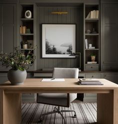 a home office with built in bookshelves and desk, along with an art print on the wall