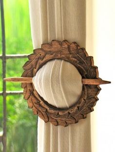 a mirror hanging on the side of a window sill in front of a curtain