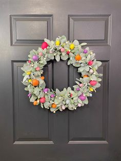 a wreath on the front door decorated with easter eggs