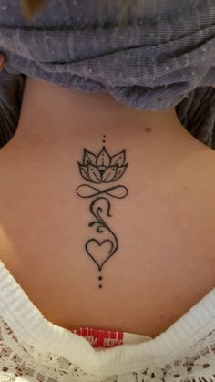 a woman with a lotus tattoo on her lower back and the word love written in cursive writing