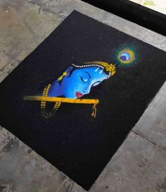 a blue and yellow painting on the ground next to a sidewalk with a black background