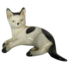 a black and white cat figurine laying down