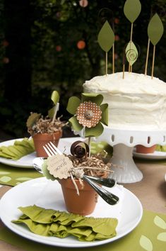 a table topped with cake and cupcakes on top of white plates covered in green napkins