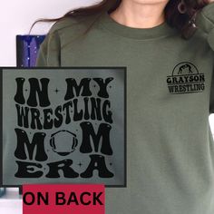 a woman wearing a green shirt with the words in my wrestling mom era on it