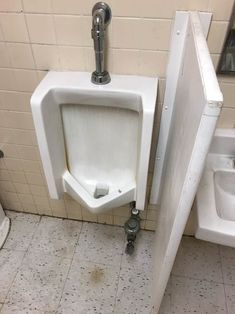 a urinal in a bathroom next to a sink