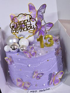 a birthday cake with purple frosting and gold decorations